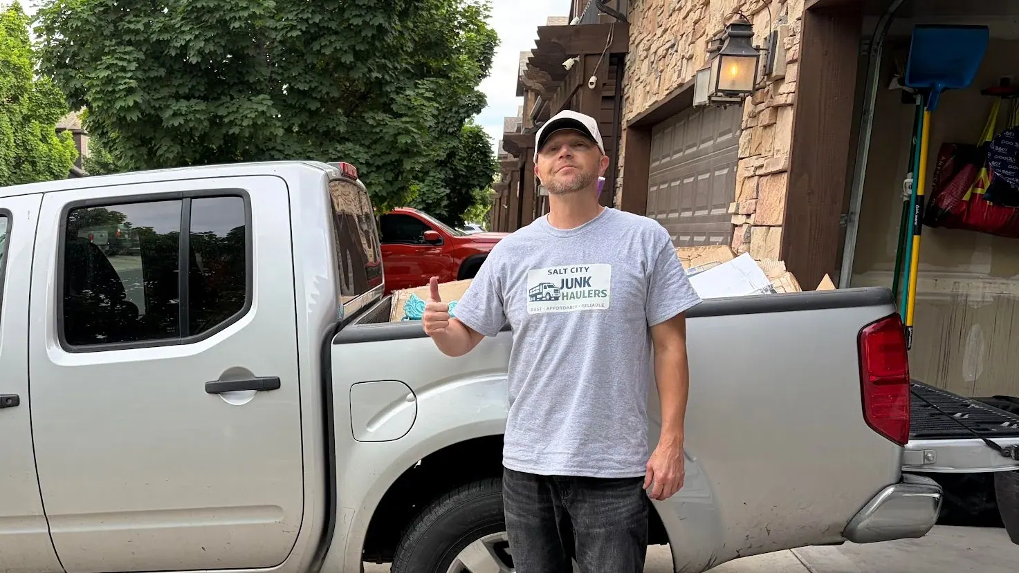 Jeremy standing beside the Salt City Junk Haulers pickup in a driveway
