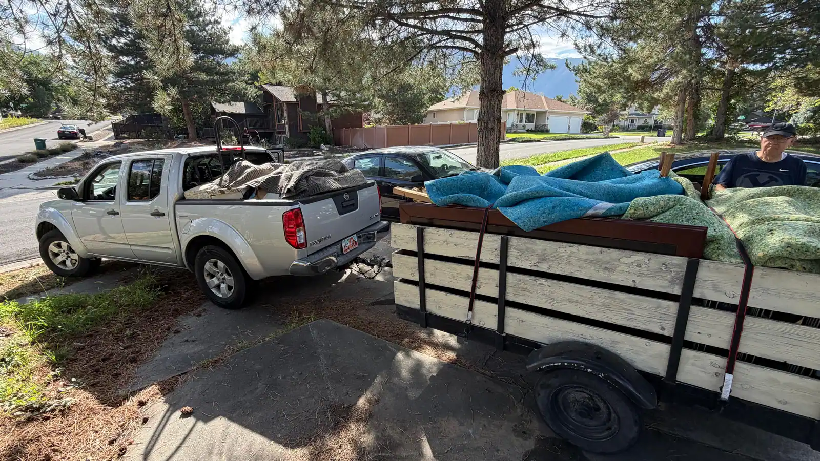 Jeremy's pickup and trailer loaded with old carpet on a tree-lined Salt Lake Valley street