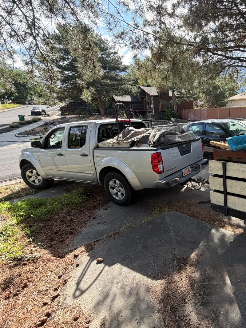Truck and trailer loaded with carpet from a side yard cleanout
