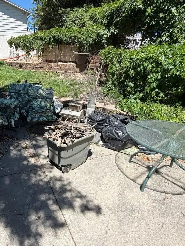 Old grill and patio set staged for junk pickup
