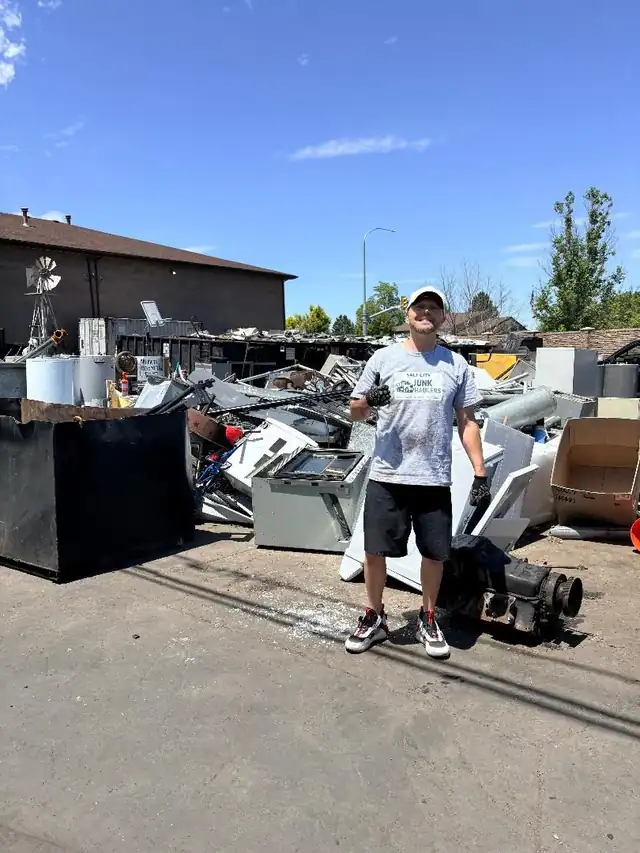 Jeremy at the metal recycler with a pile of old appliances